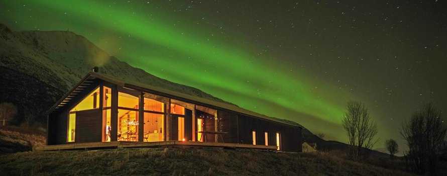 Moderne hut in de avond met noorderlicht