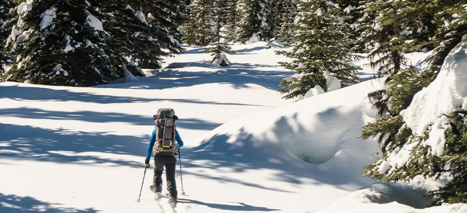 Mann som går på ski i norsk natur