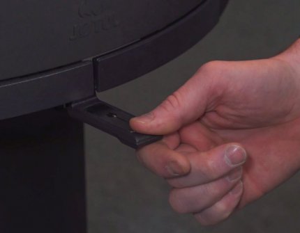 Hand die de luchttoevoer in de haard regelt