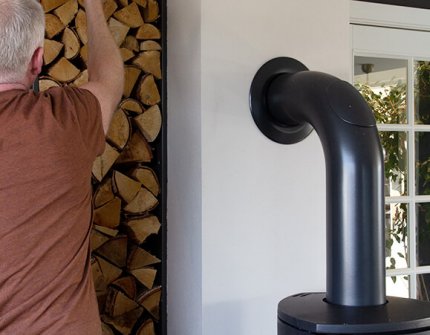 Man die hout neemt om in de open haard te zetten