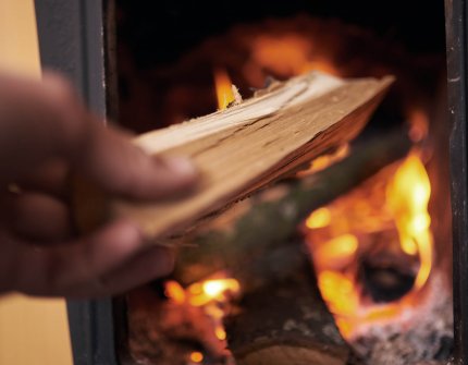 hand die een brandhout in de open haard legde