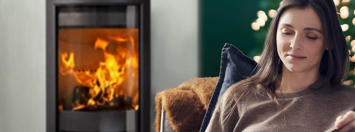 Vrouw voor haar open haard met kerst