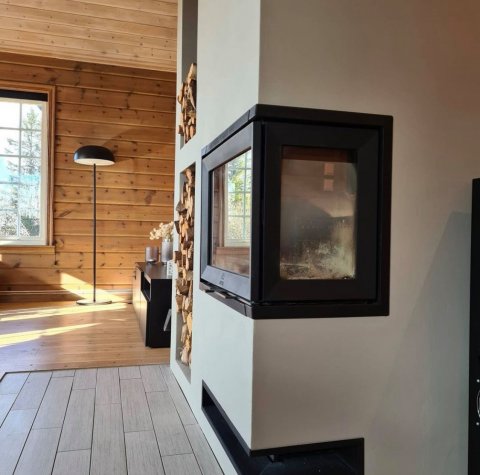 Witte omlijsting met een zwart inzetstuk genaamd Jøtul I 520 FR in een Noorse cabine.