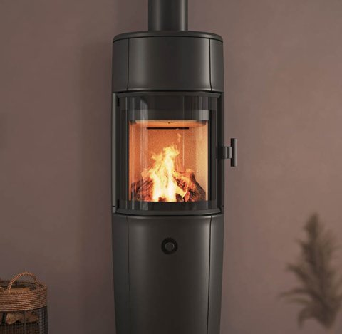 Moderne kamer met grote zwarte Jøtul F 174 houtkachel, poederpaarse muren