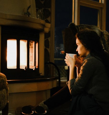 Dame die 's avonds voor de open haard zit